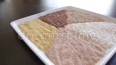 一个盘子里的几种谷物。 荞麦，<strong>大米</strong>，<strong>小米</strong>，大麦，藜麦。 摄像机绕着这个向左移动